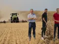Rolnicy dyskutują o uproszczonych systemach uprawy, podczas gdy traktor orze pole.