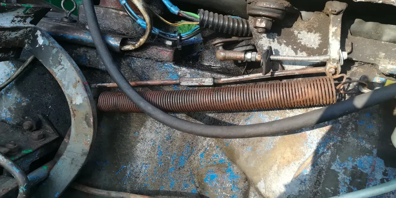 Widok na mechanizm cięgna gazu c 360 z widocznymi sprężynami, przewodami i elementami mocowania.