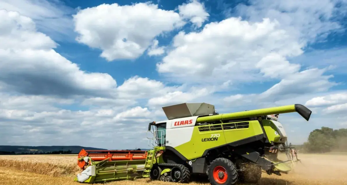 Kombajn Claas Lexion 770 pracuje na polu, zbierając zboże. To jeden z wielu znanych **marek kombajnów**.