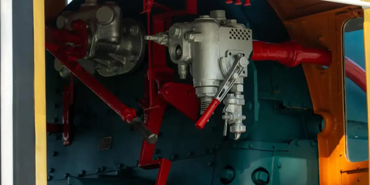 Mechanizm sterowania lokomotywy, z widocznymi elementami hydraulicznymi. Może to być oznaka awarii hydraulicznej, wymagającej naprawy.
