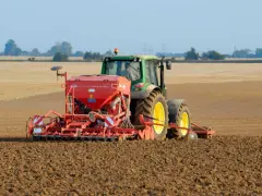 Zielony traktor z siewnikiem KUHN VENTA LC 303 precyzyjnie ustawia głębokość siewu rzepaku na przygotowanym polu.