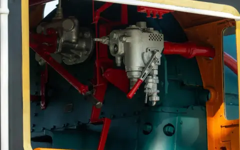 Mechanizm sterowania lokomotywy, z widocznymi elementami hydraulicznymi. Może to być oznaka awarii hydraulicznej, wymagającej naprawy.