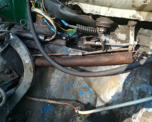 Widok na mechanizm cięgna gazu c 360 z widocznymi sprężynami, przewodami i elementami mocowania.