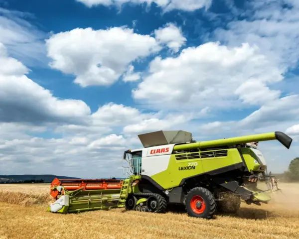 Kombajn Claas Lexion 770 pracuje na polu, zbierając zboże. To jeden z wielu znanych **marek kombajnów**.