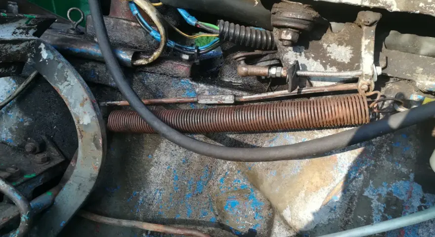 Widok na mechanizm cięgna gazu c 360 z widocznymi sprężynami, przewodami i elementami mocowania.