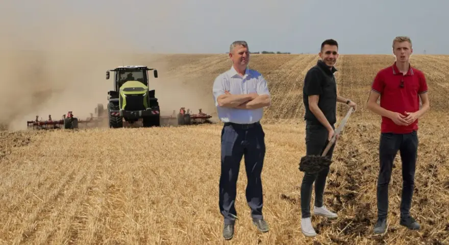 Rolnicy dyskutują o uproszczonych systemach uprawy, podczas gdy traktor orze pole.