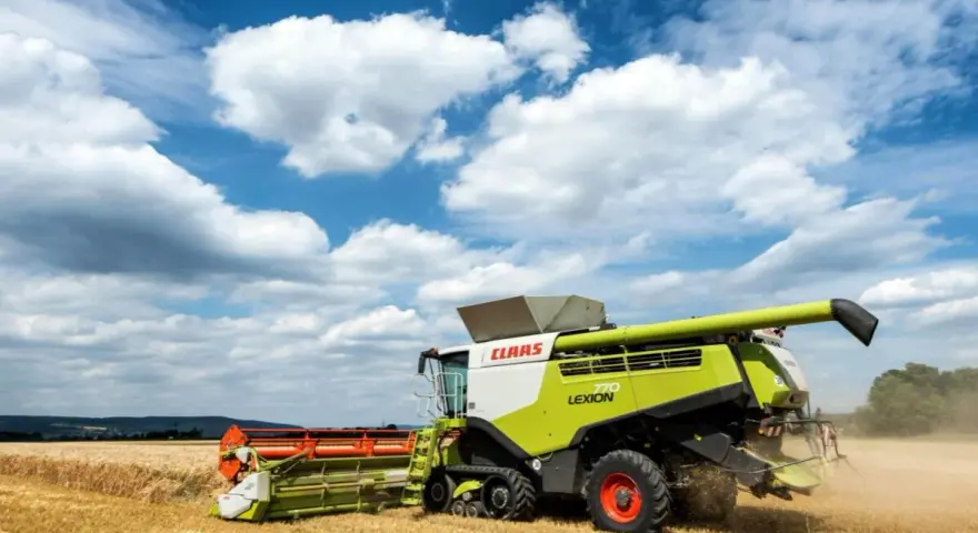 Kombajn Claas Lexion 770 pracuje na polu, zbierając zboże. To jeden z wielu znanych **marek kombajnów**.