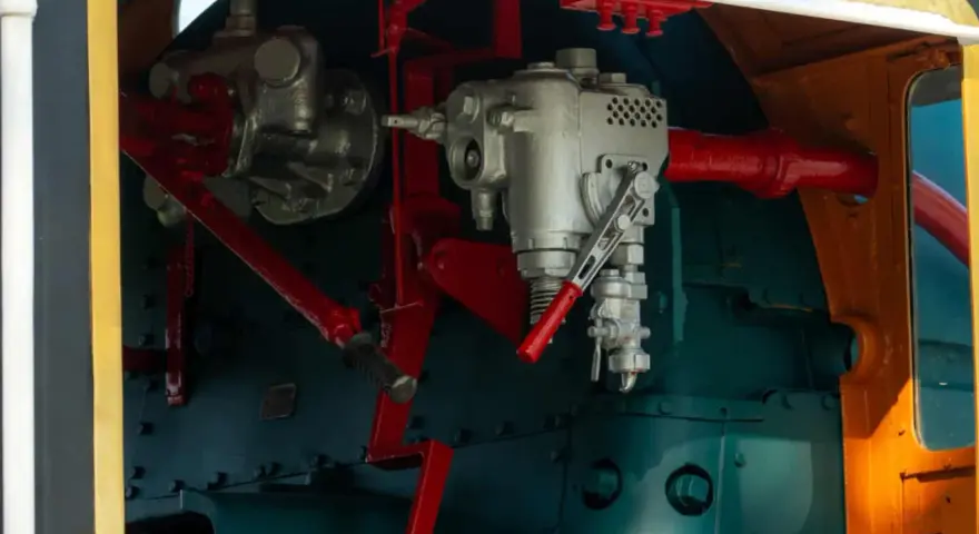Mechanizm sterowania lokomotywy, z widocznymi elementami hydraulicznymi. Może to być oznaka awarii hydraulicznej, wymagającej naprawy.