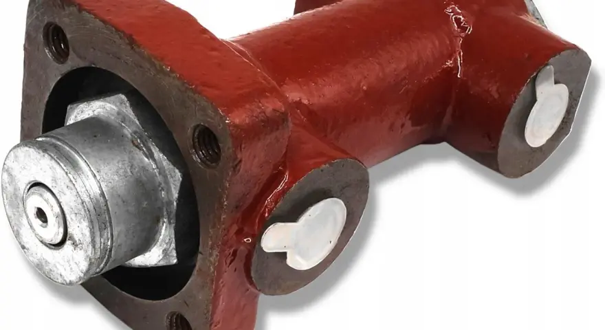 Część hamulca ciągnika Zetor: metalowy element z czerwonym korpusem i srebrnymi zaślepkami.