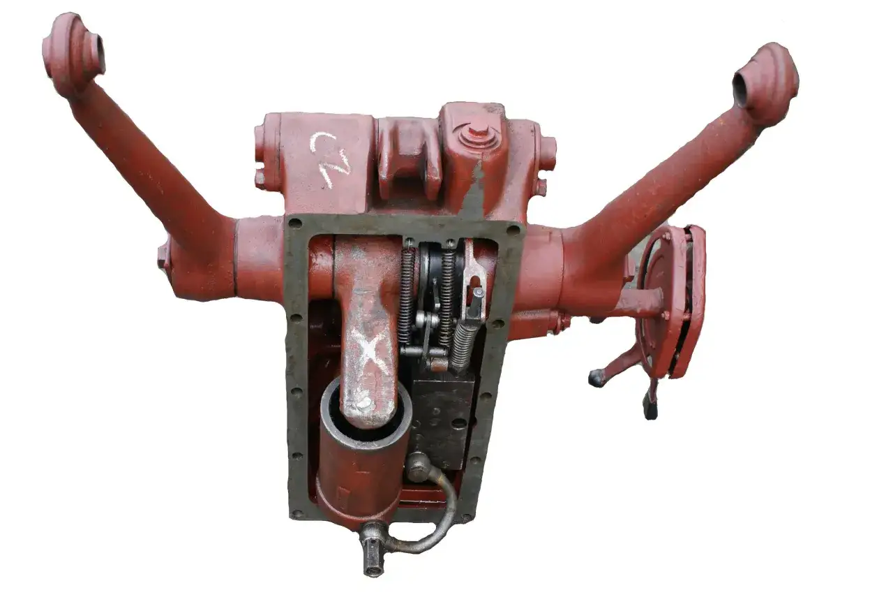 Część mechanizmu podnośnika Ursusa C-360: czerwony cylinder podnośnika z widocznymi elementami hydraulicznymi i dźwigniami.